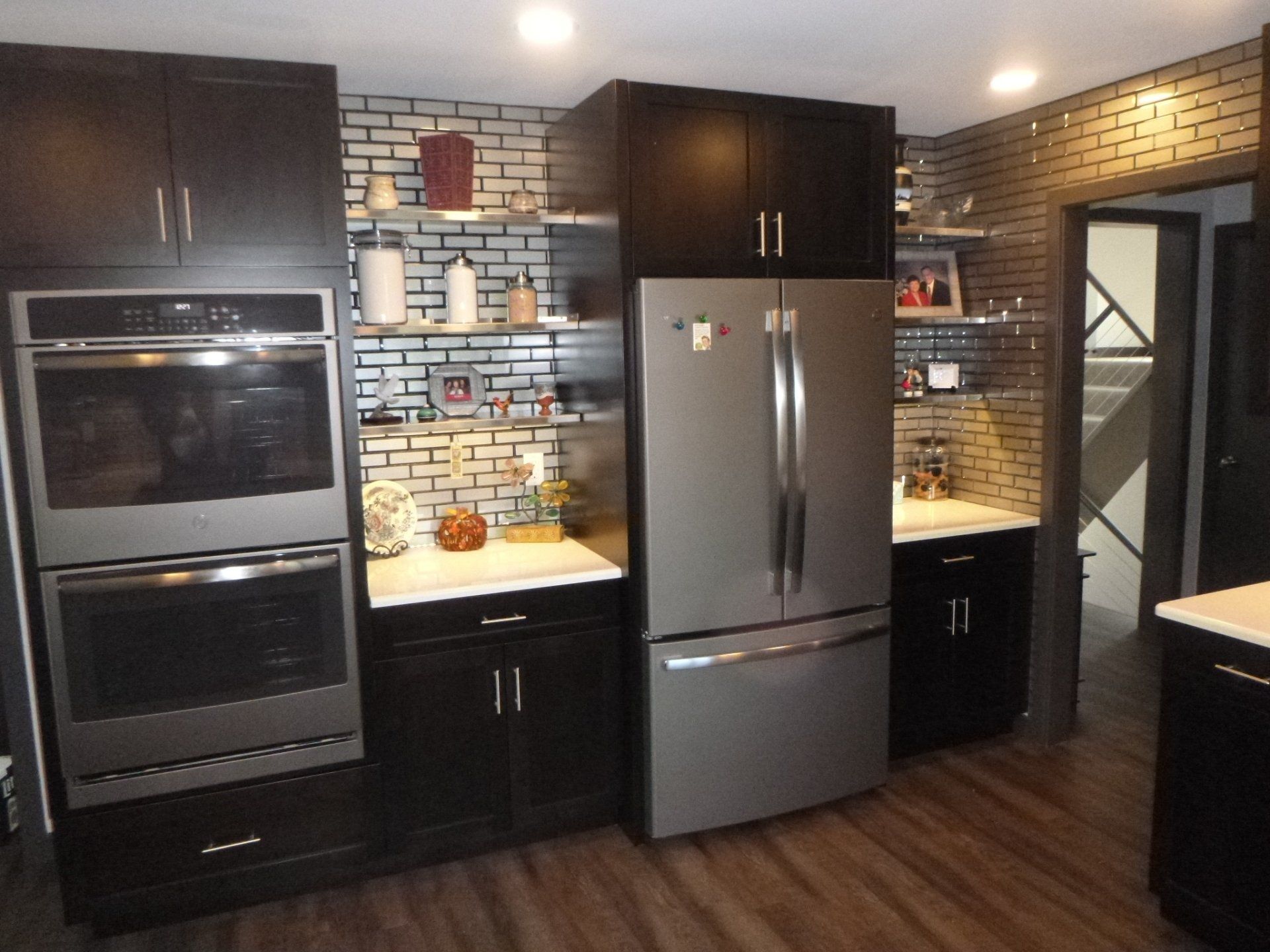 A kitchen with stainless steel appliances and black cabinets