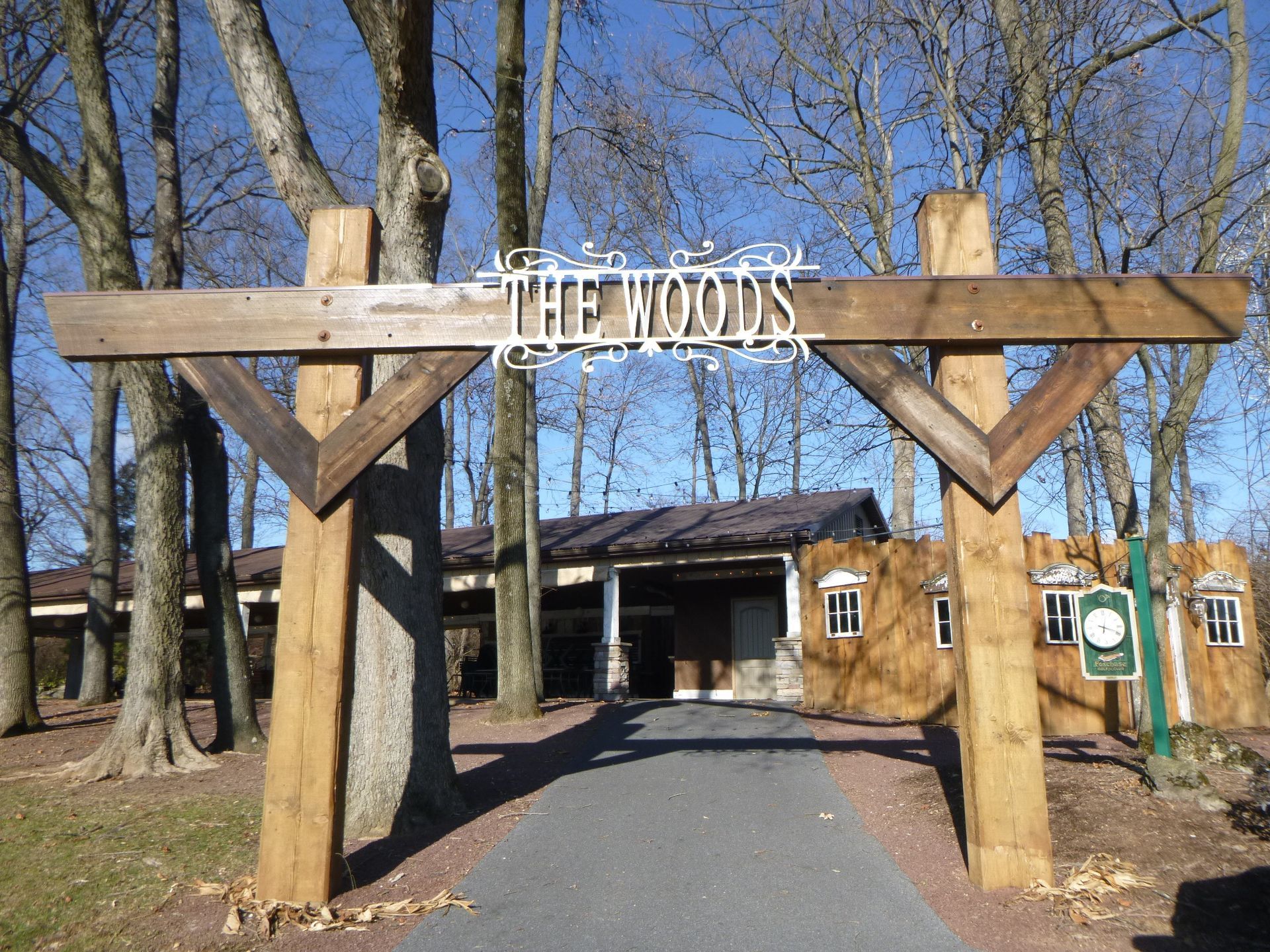A wooden sign that says the woods on it