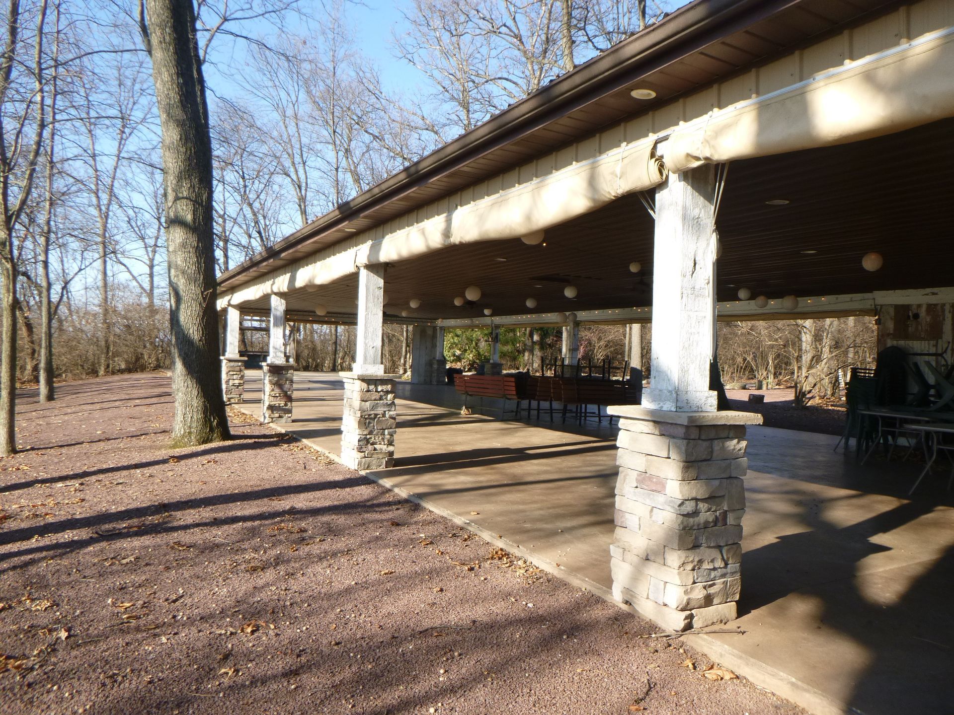 A pavilion in the middle of a forest with trees in the background