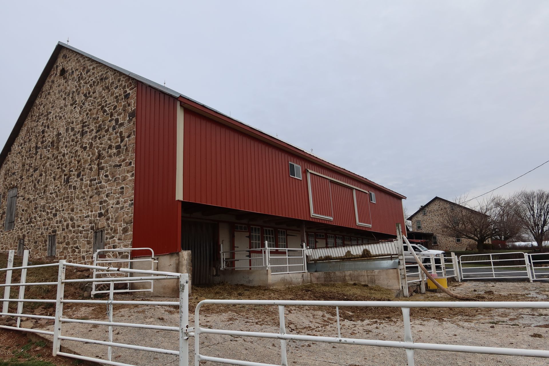 A red barn with a white fence around it