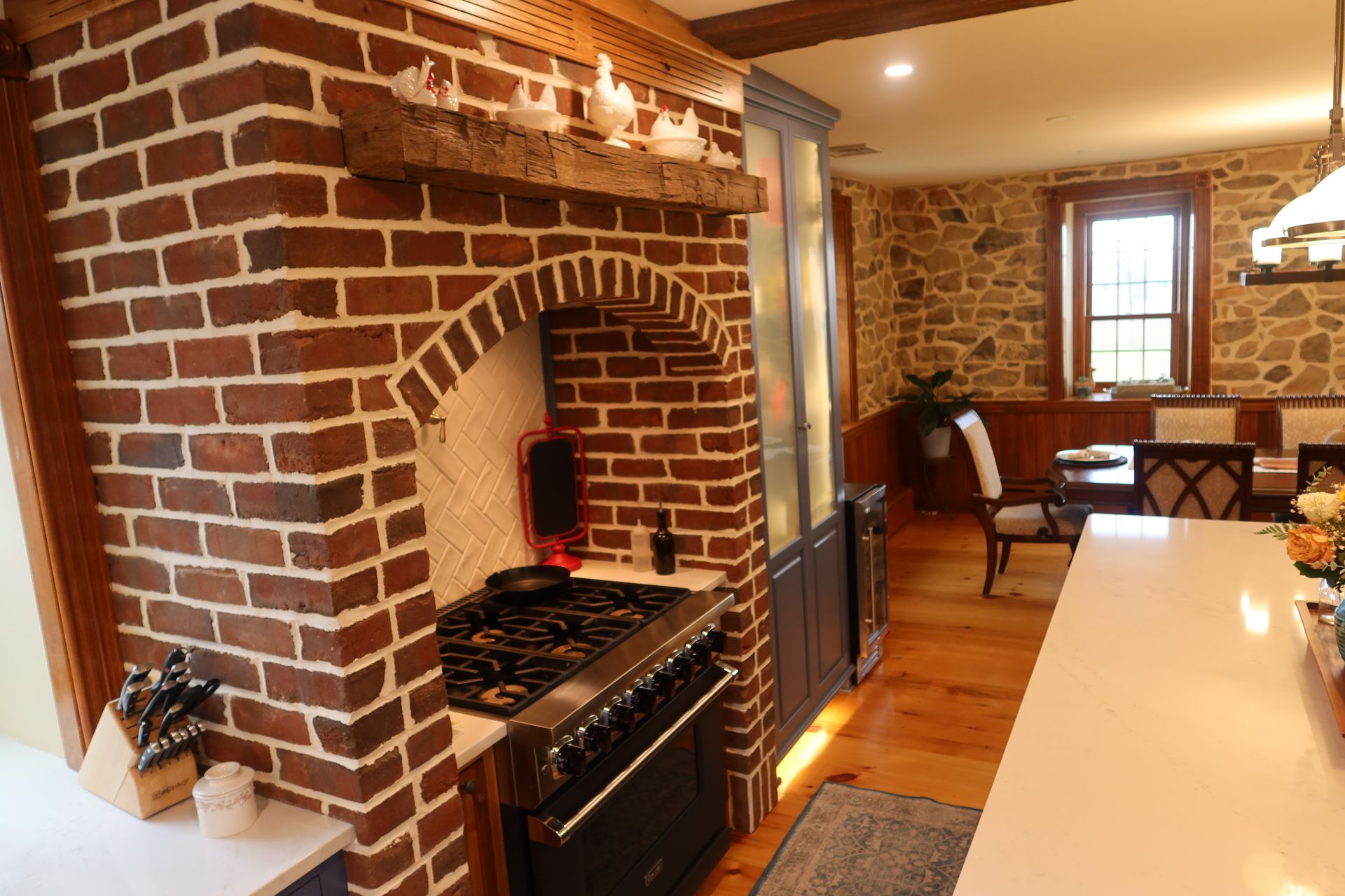 A kitchen with a stove and a brick fireplace.