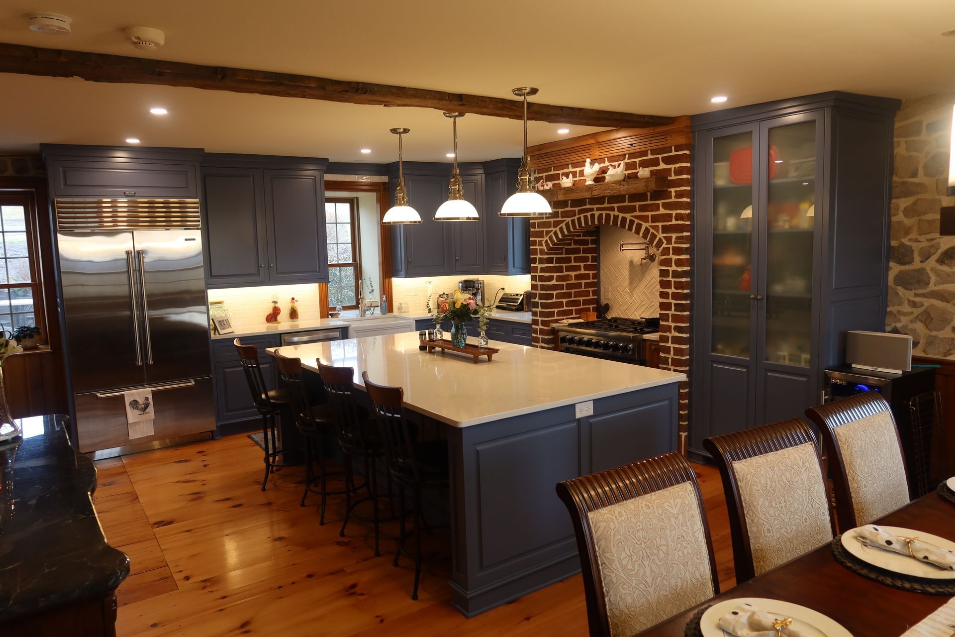 A kitchen with a large island in the middle and a dining room in the background.