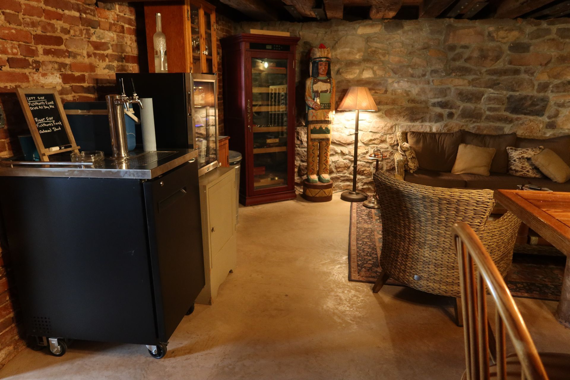 A living room with a brick wall , a couch , a table and chairs.