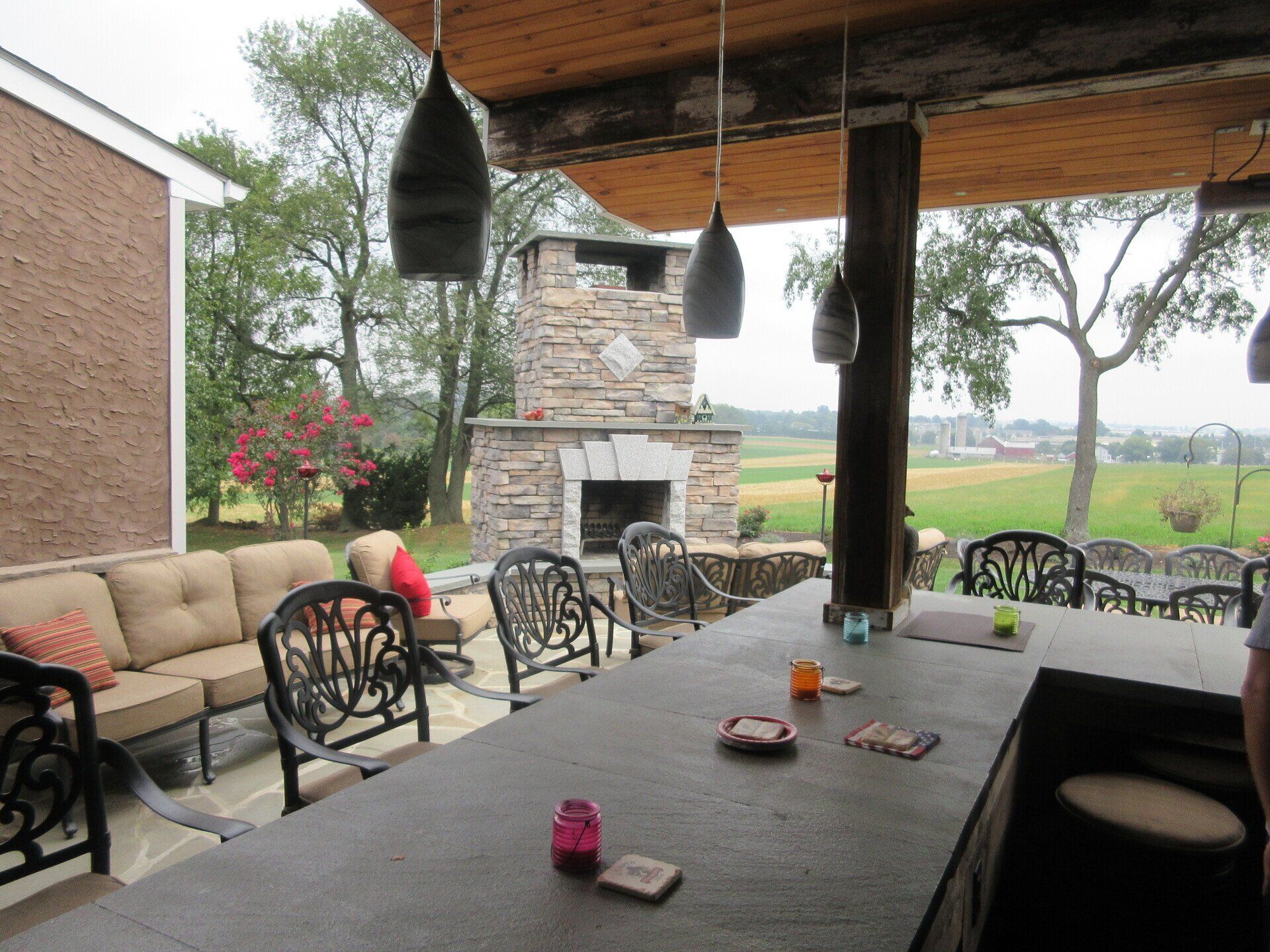 A patio with a large table and chairs and a fireplace
