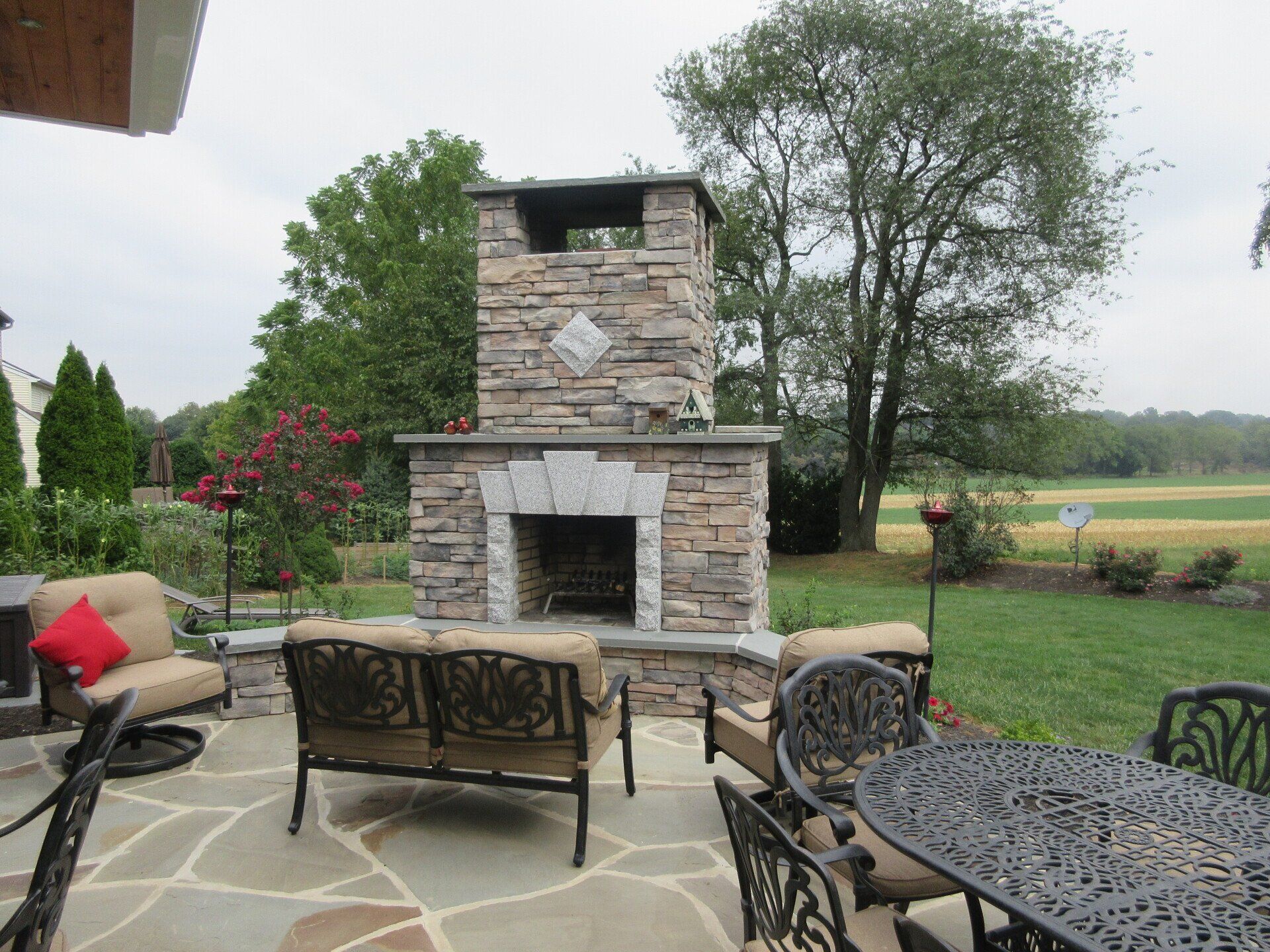 A patio with a fireplace and a table and chairs