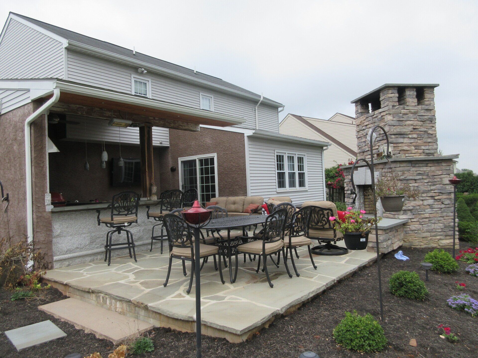 A patio with a table and chairs in front of a house