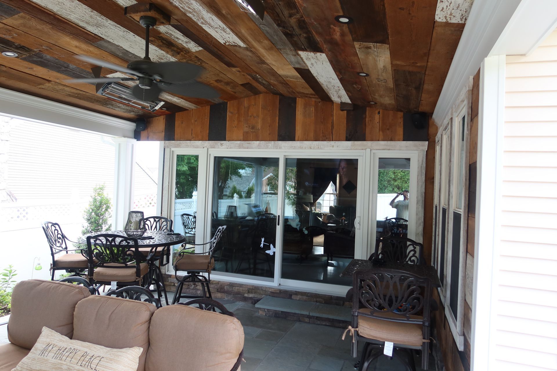 A living room with a couch and chairs and a ceiling fan