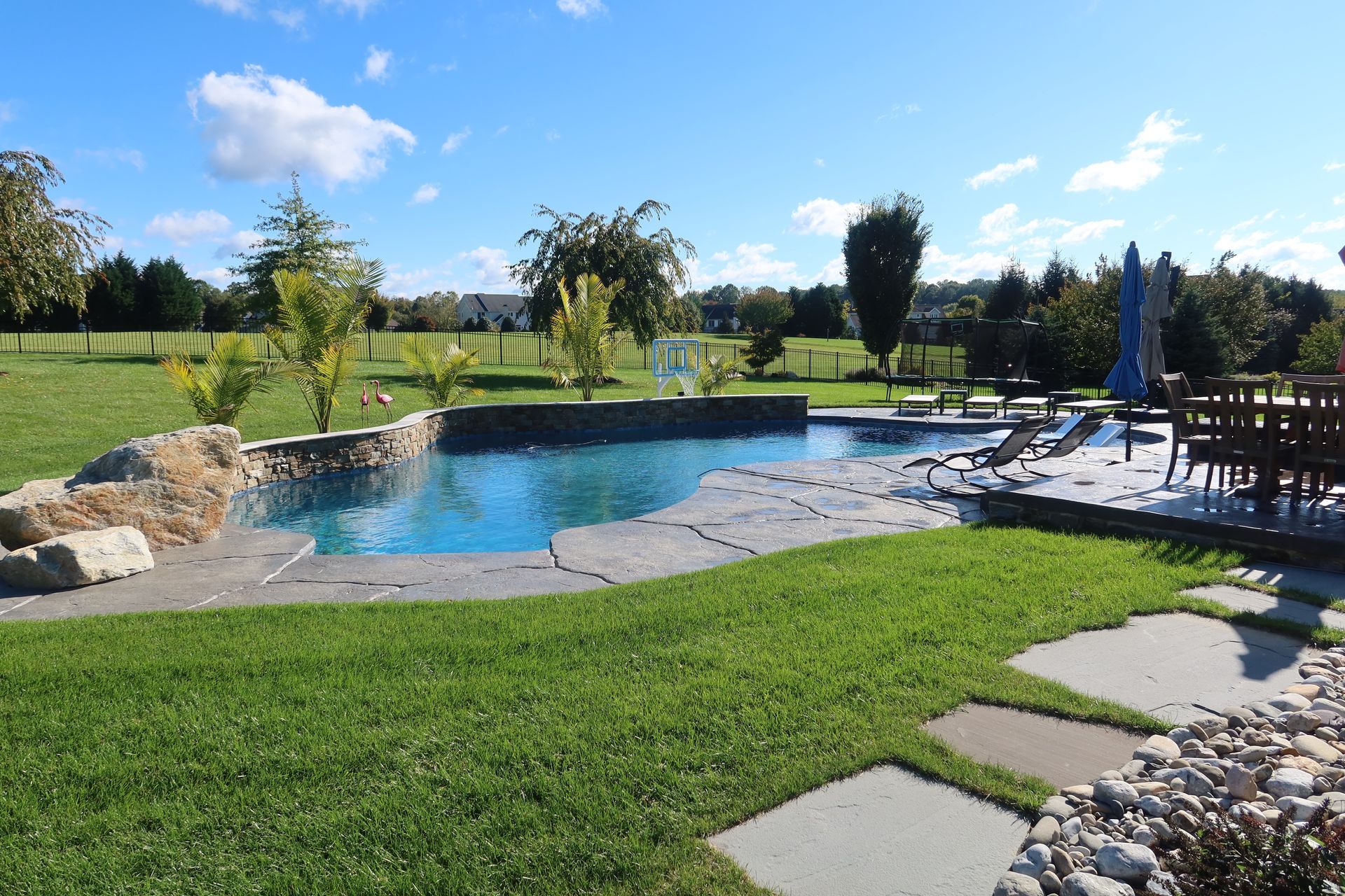 A large swimming pool in the middle of a lush green field