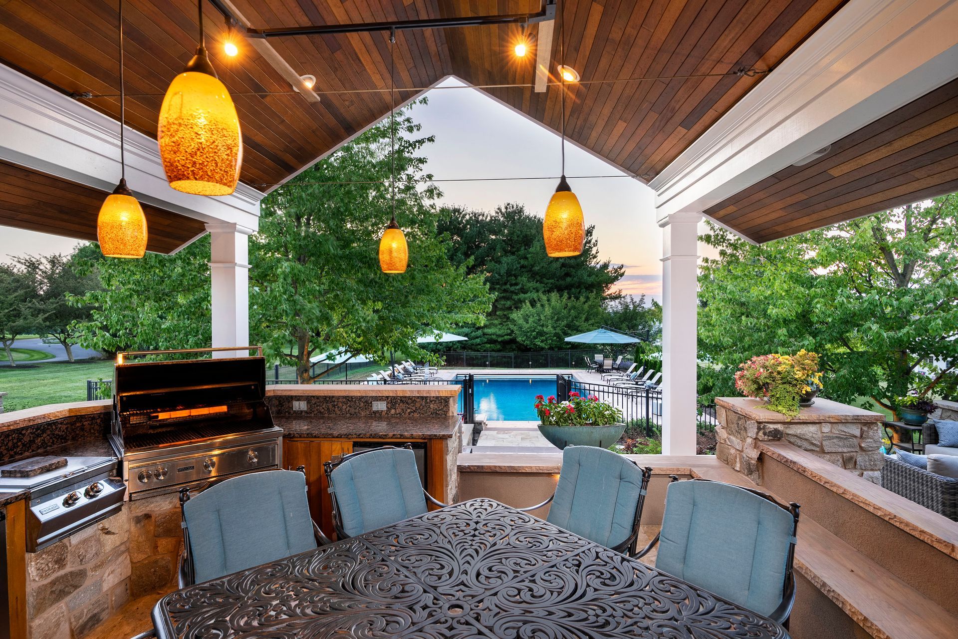 A patio with a table and chairs and a swimming pool in the background
