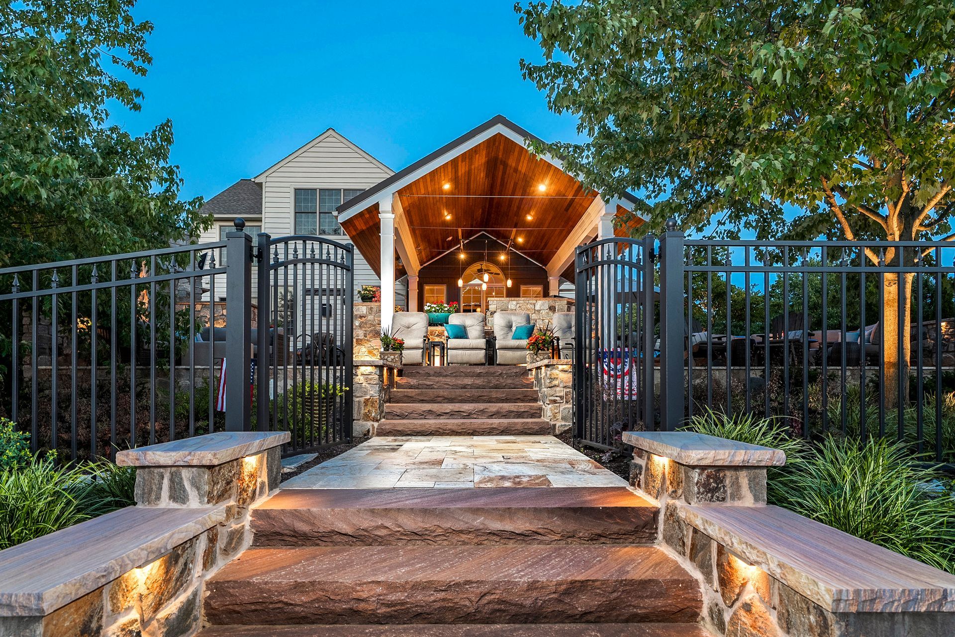 A stone walkway leading to a house with stairs leading up to it.