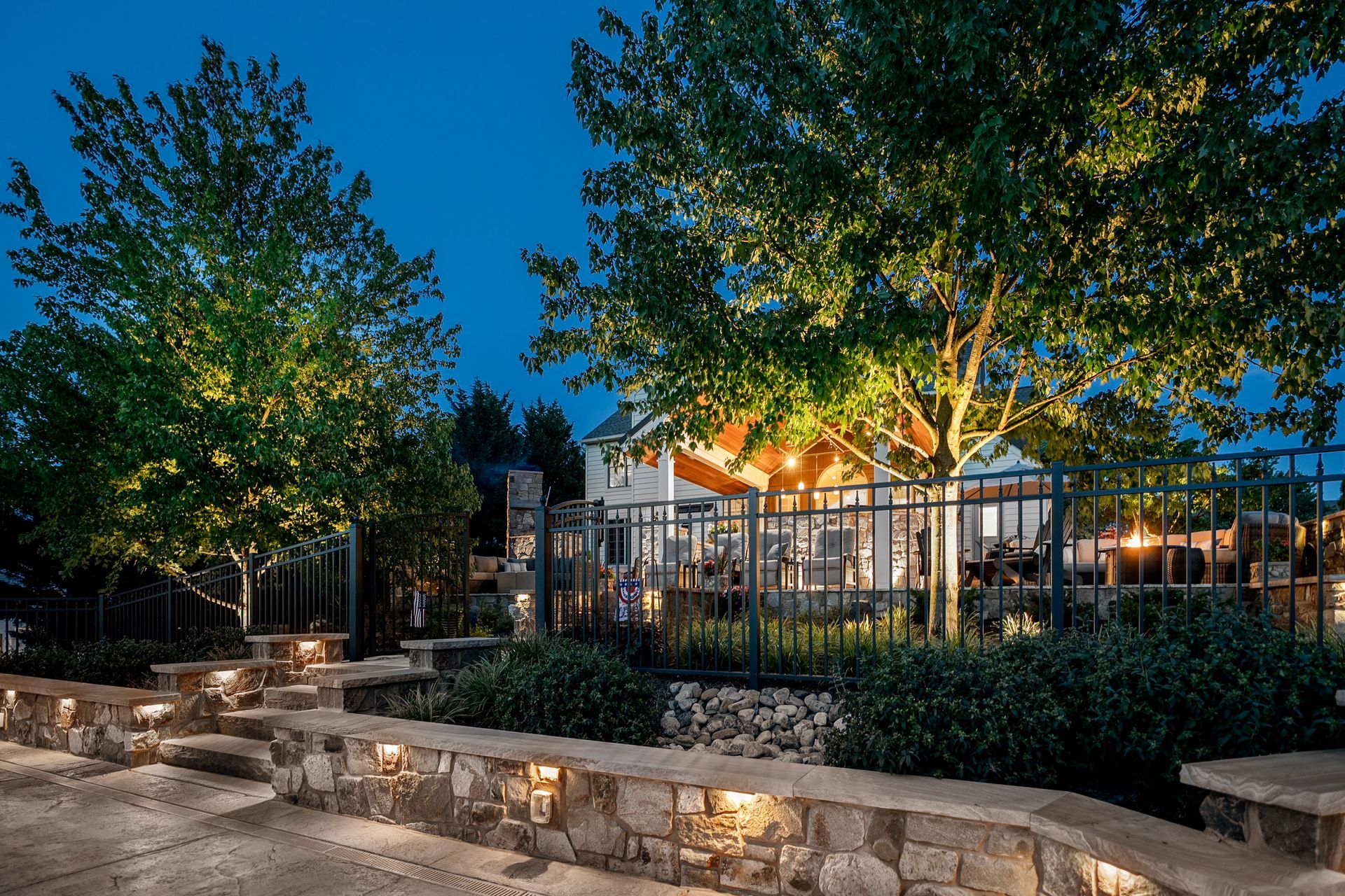 A house with a gazebo in the background is lit up at night.