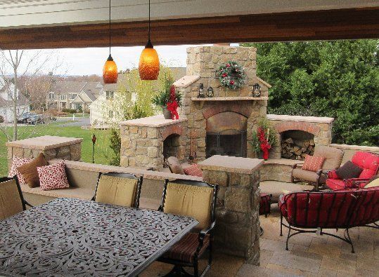 A patio with a fireplace and a table and chairs