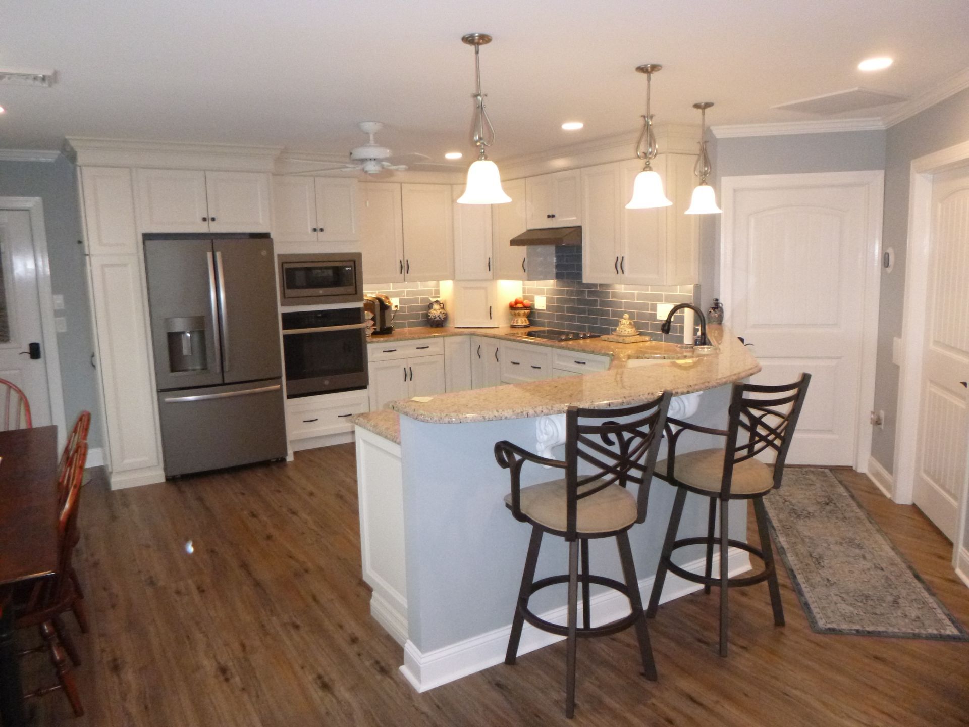 A kitchen with white cabinets and stainless steel appliances