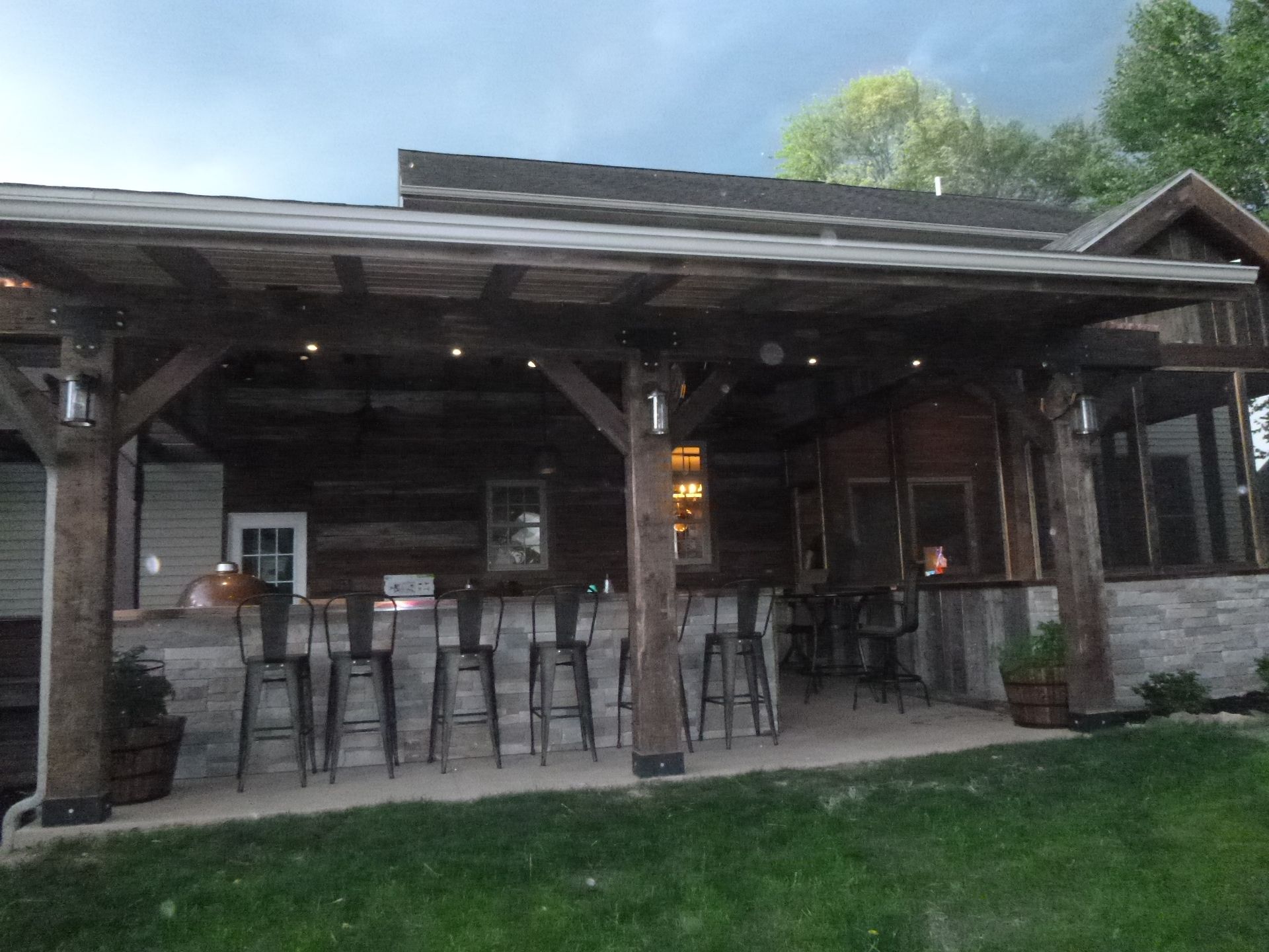 A house with a covered patio with a bar and stools
