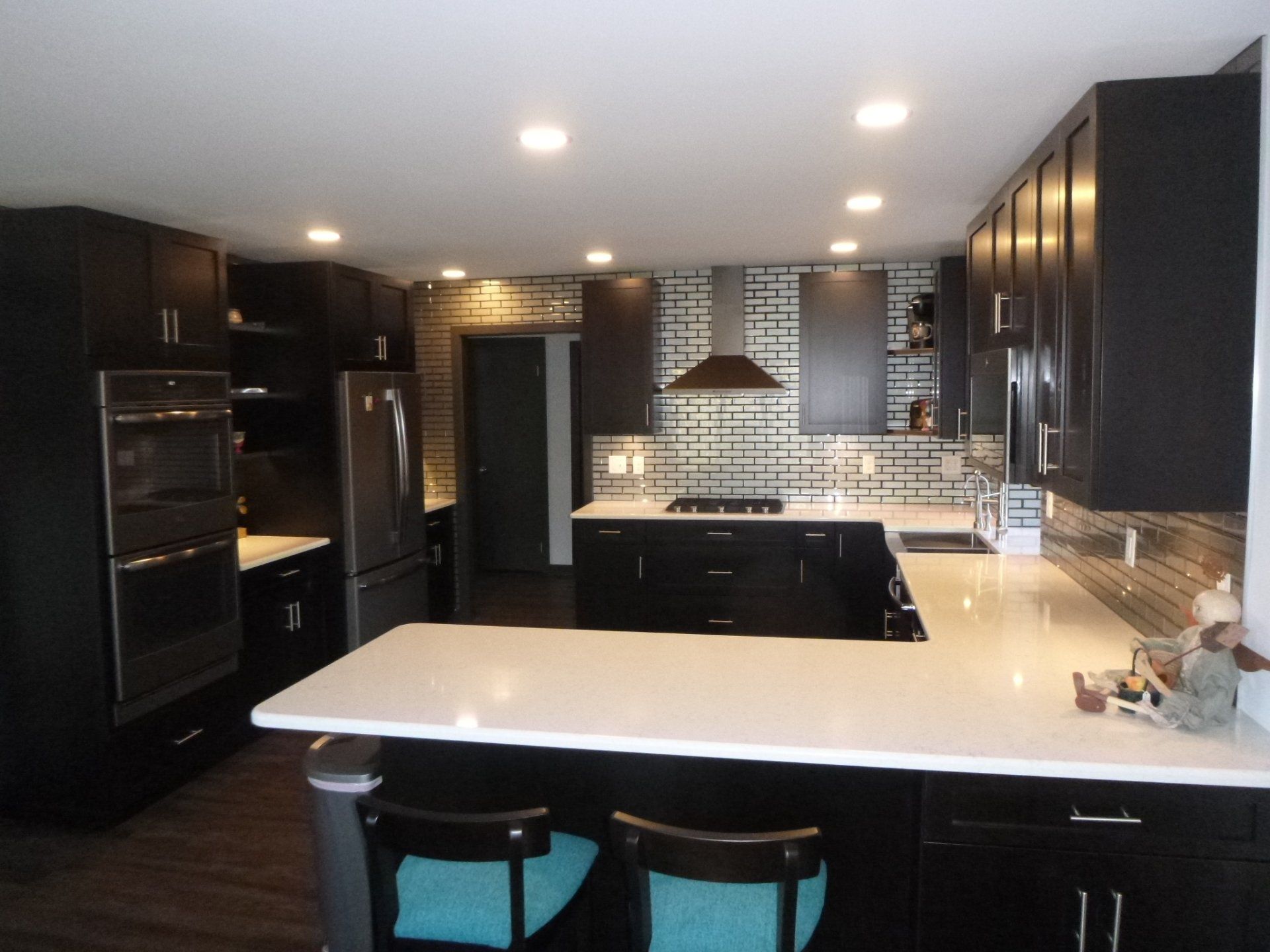 A kitchen with black cabinets and white counter tops
