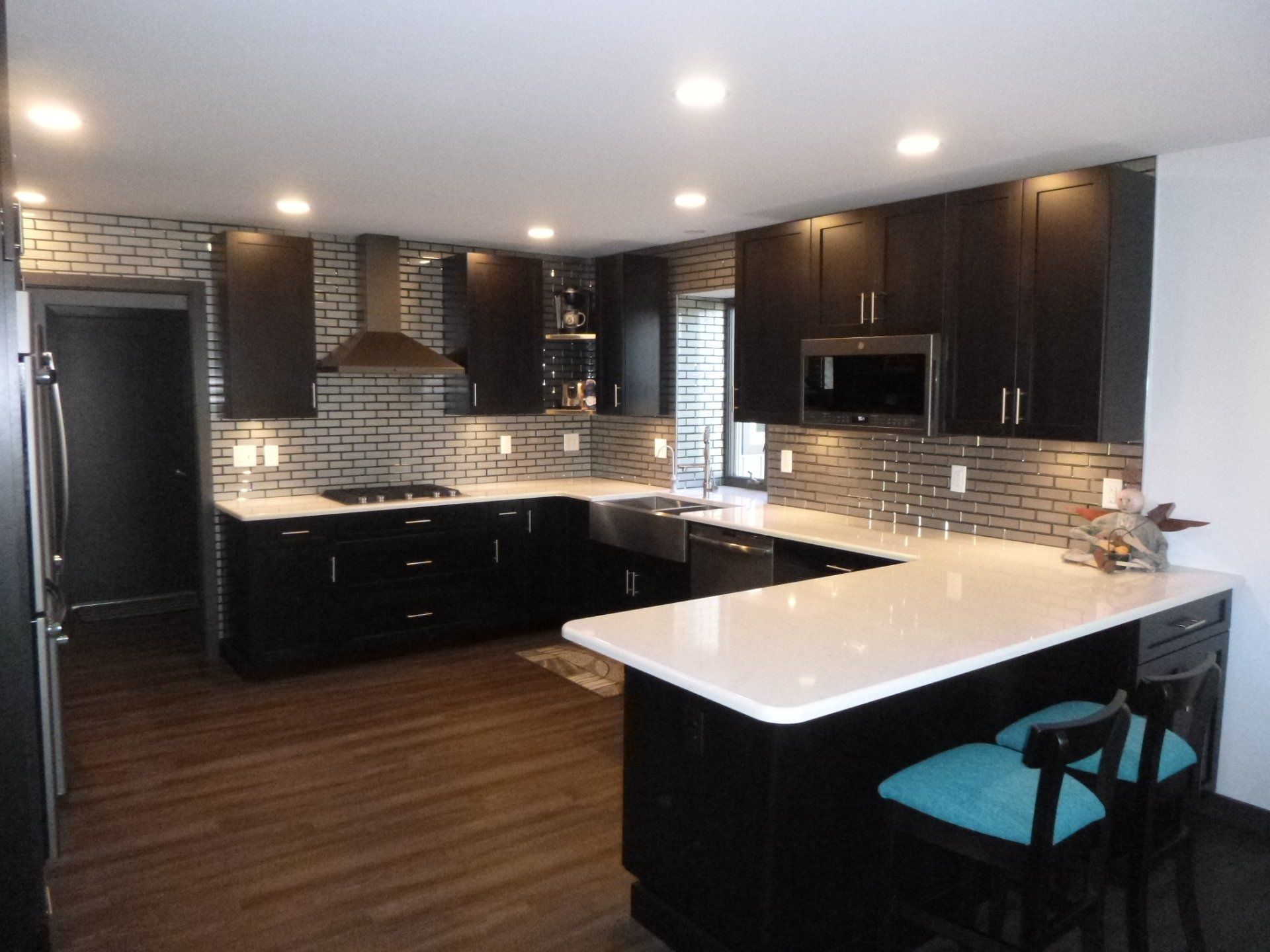 A kitchen with black cabinets and white counter tops