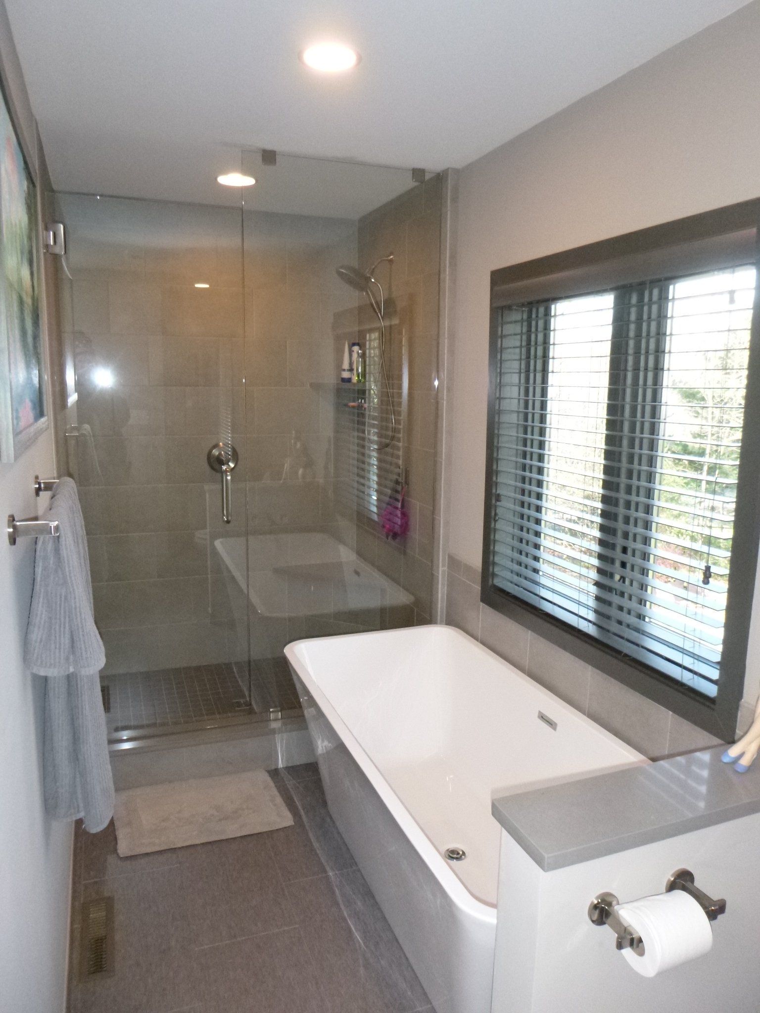 A bathroom with a bathtub , shower , and window.