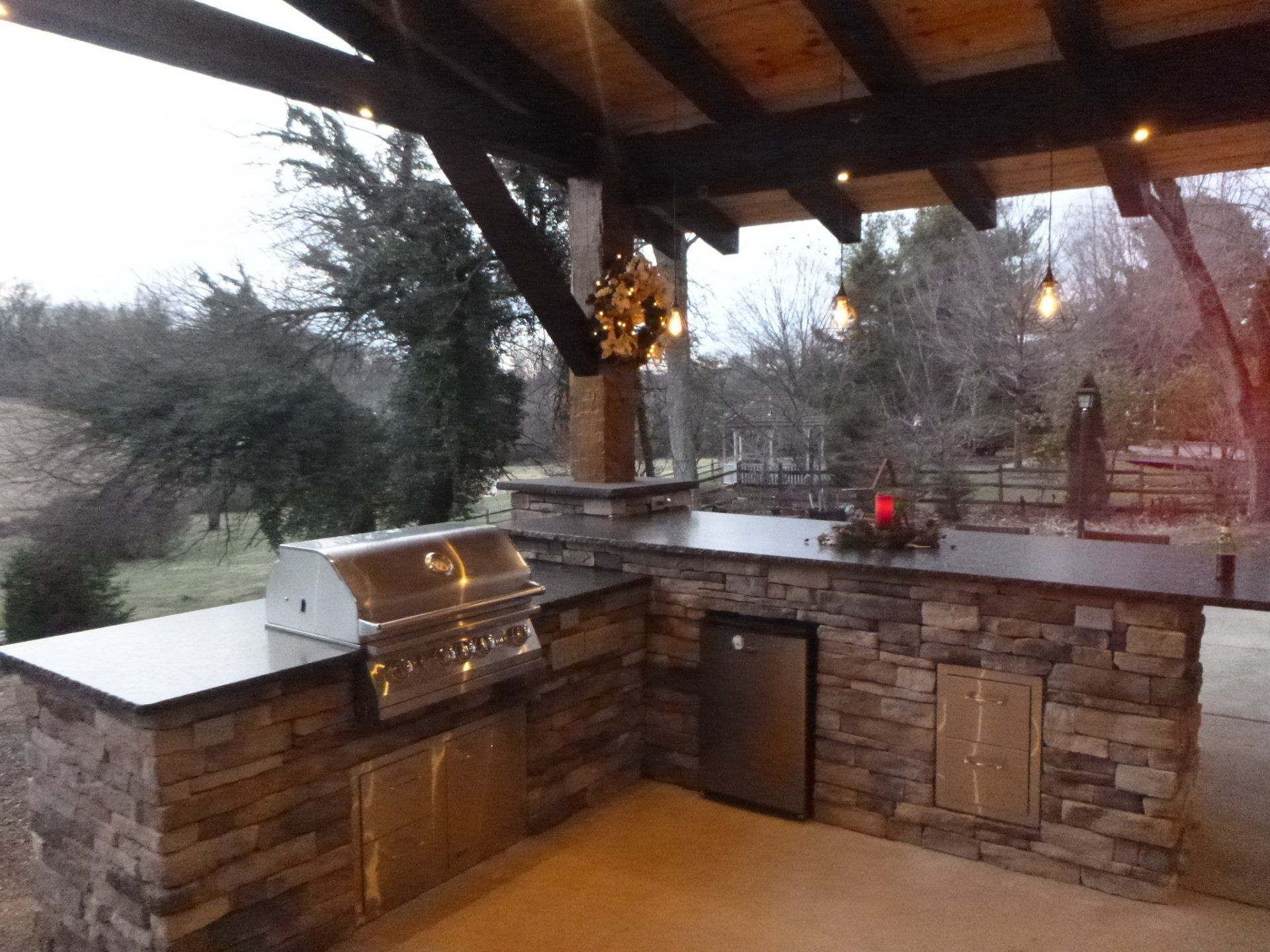 An outdoor kitchen with a grill and a stainless steel dishwasher