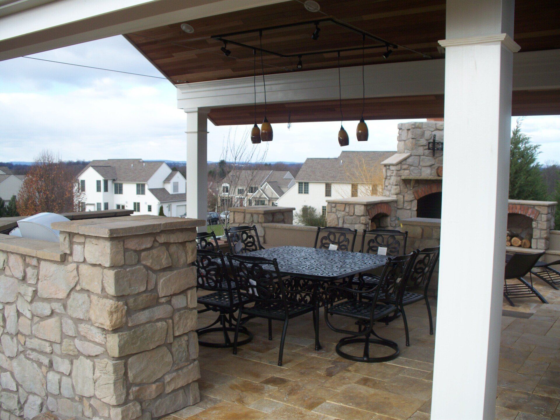 A patio with a table and chairs and a fireplace
