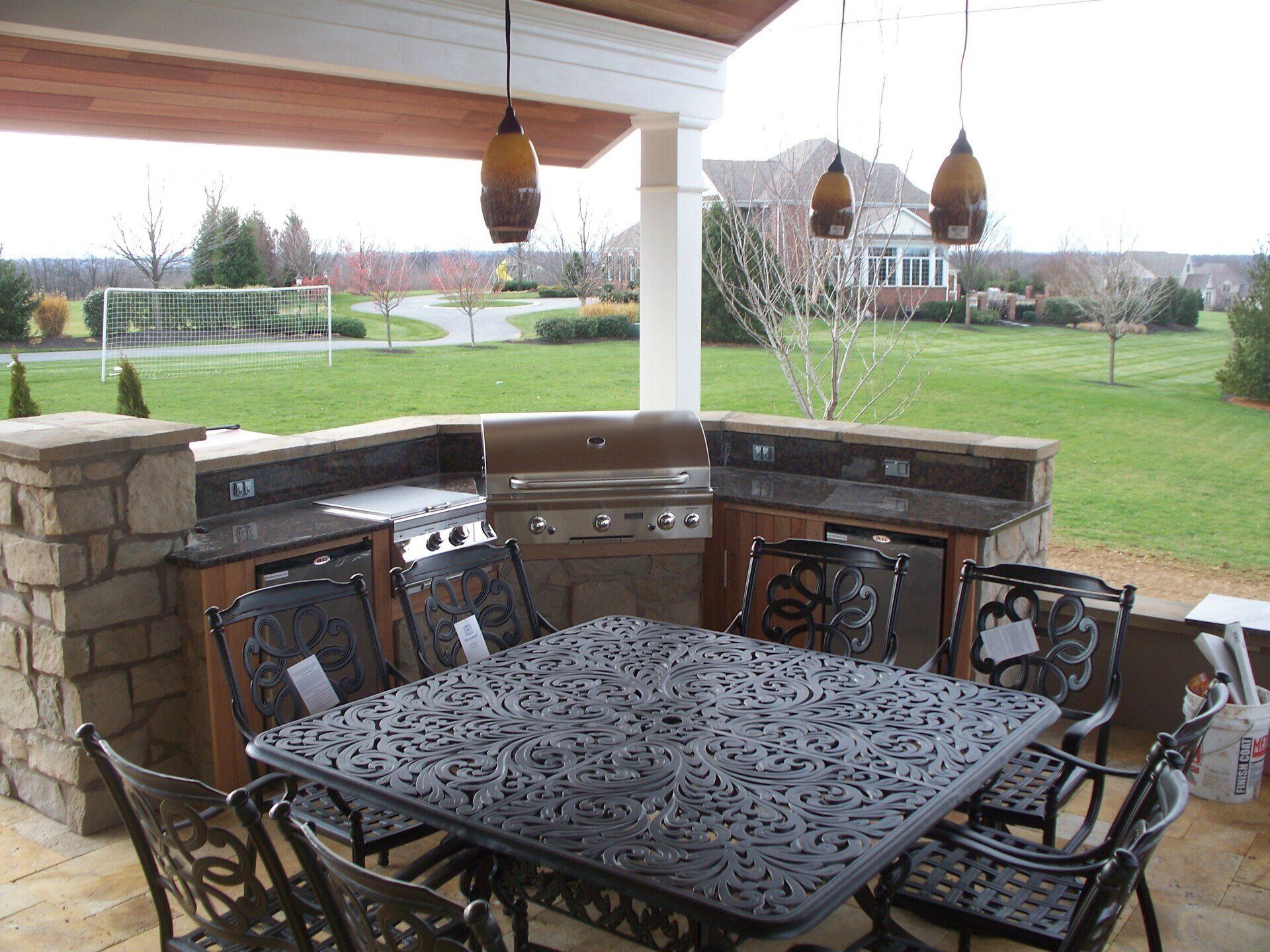 A patio with a table and chairs and a grill