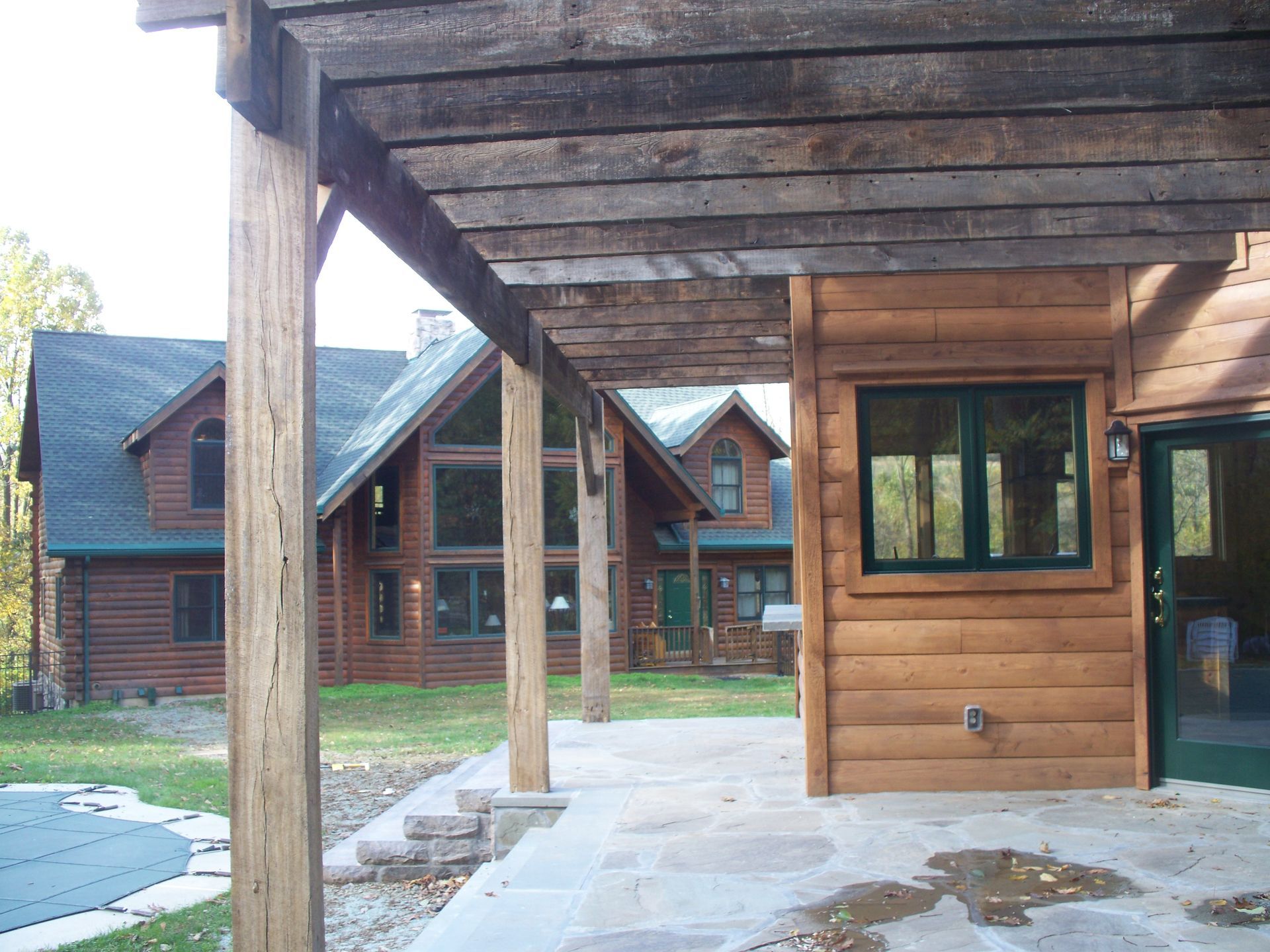 A wooden house with a covered patio in front of it