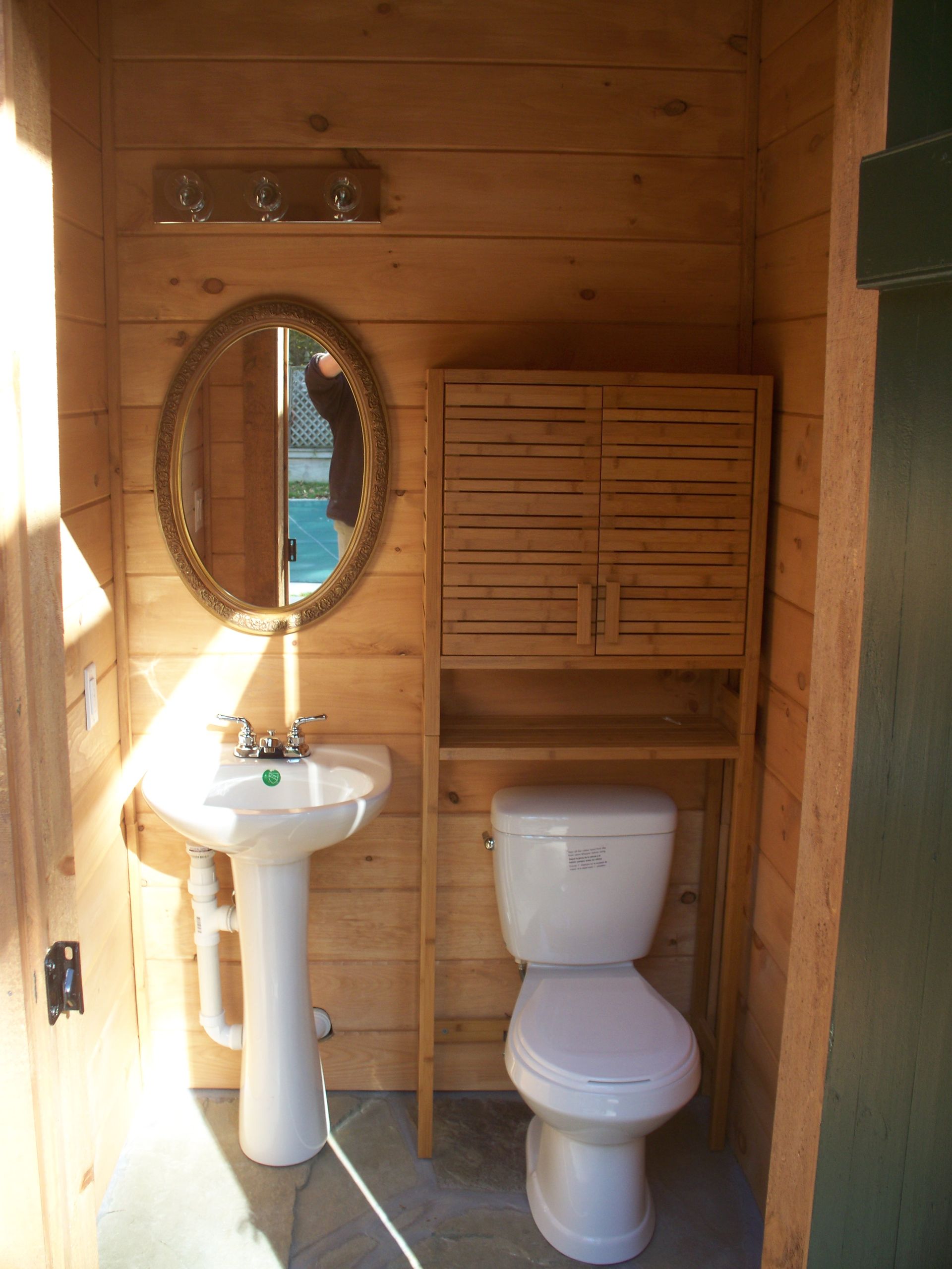 A bathroom with a toilet a sink and a mirror