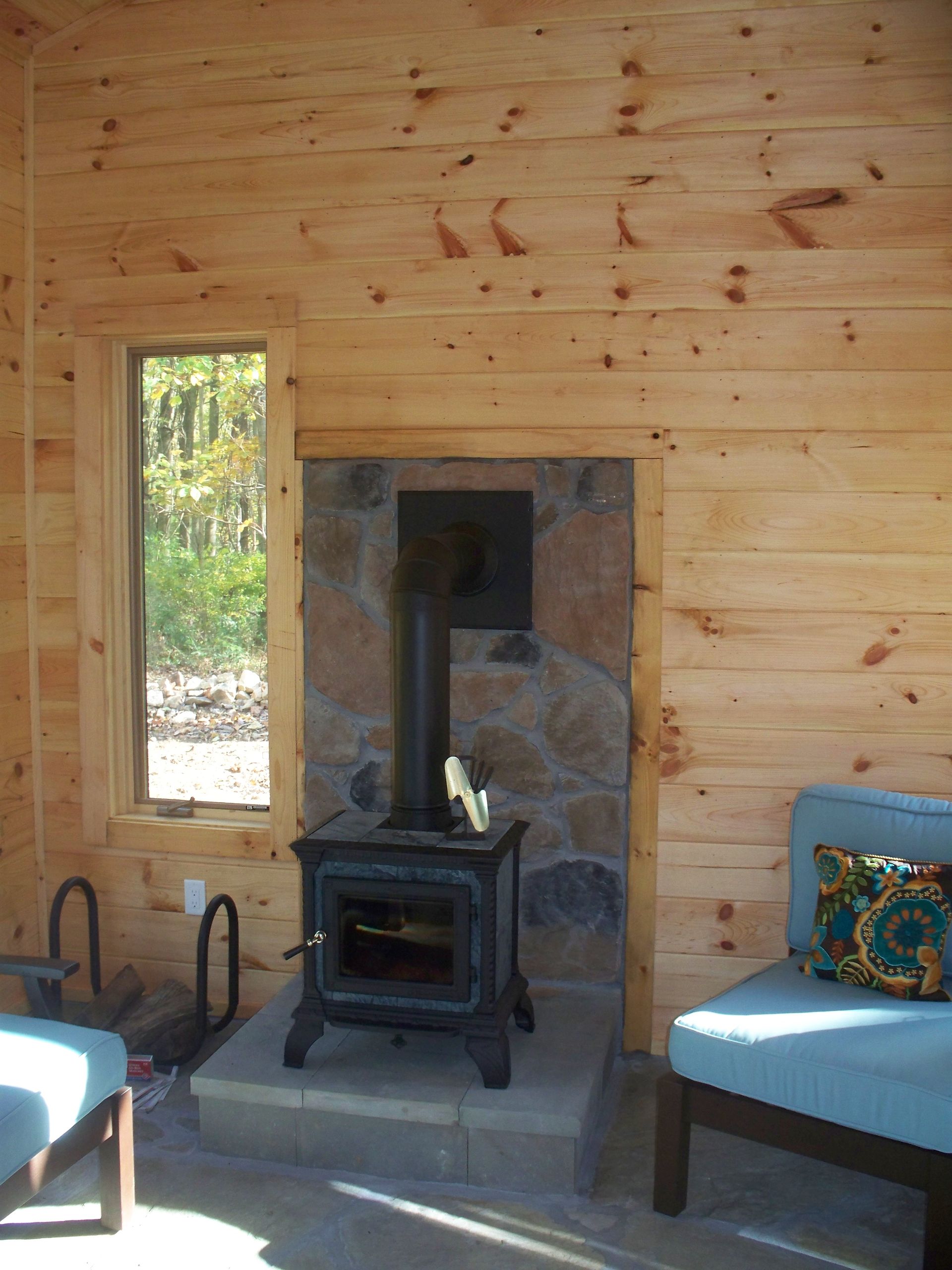 A living room with a wood stove and a window