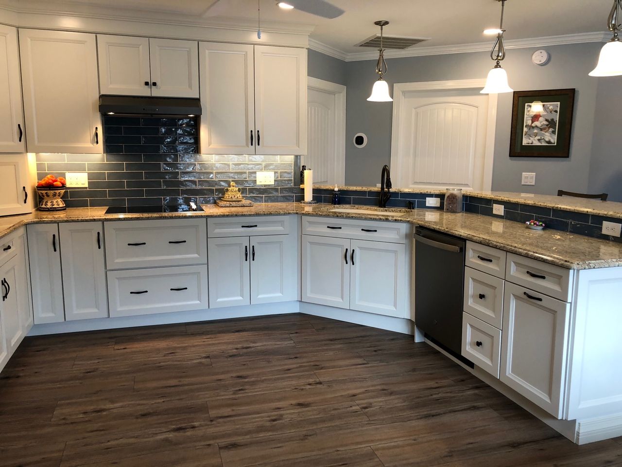 A kitchen with white cabinets and granite counter tops
