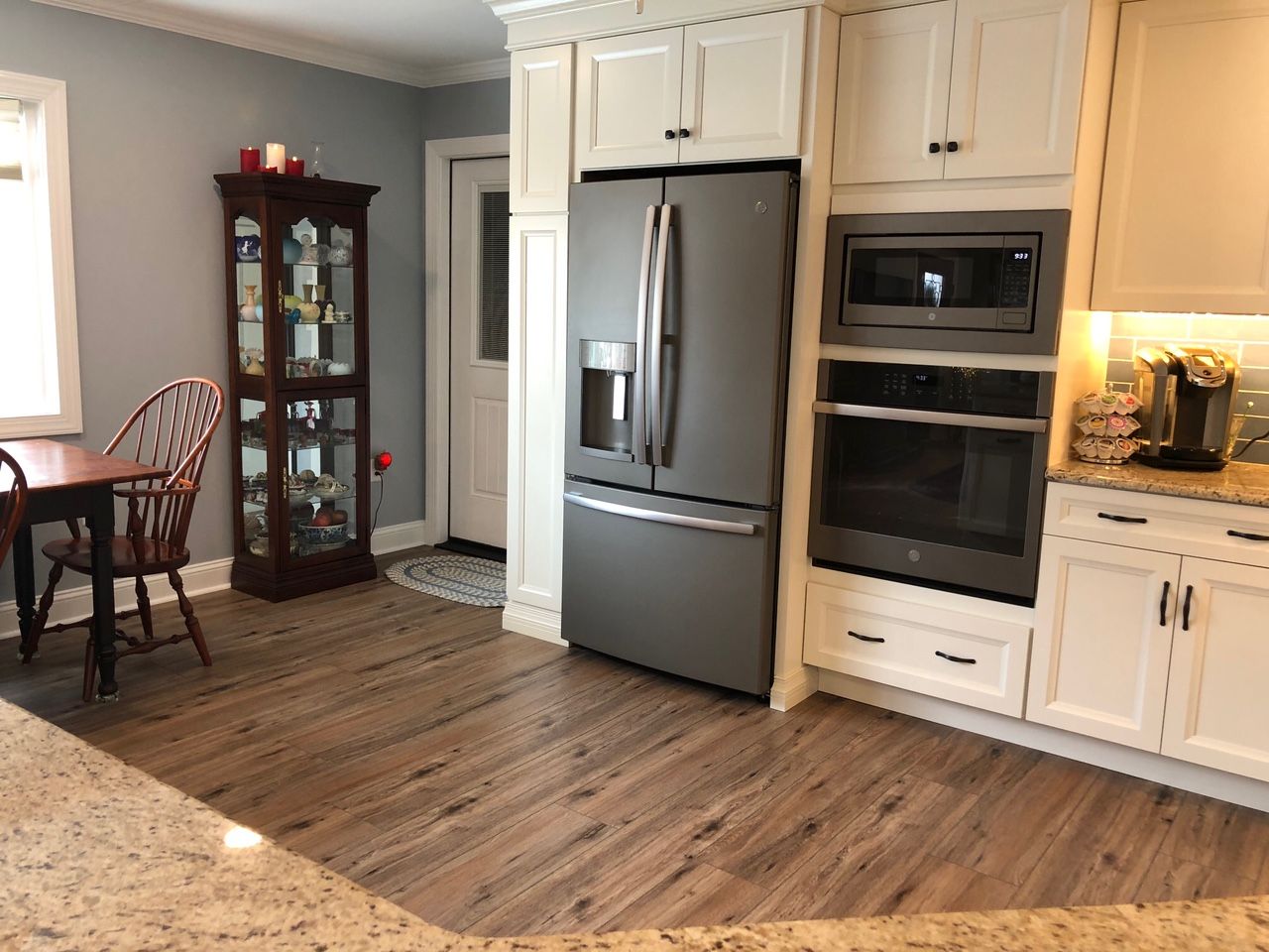 A kitchen with a refrigerator , oven , microwave and a table.