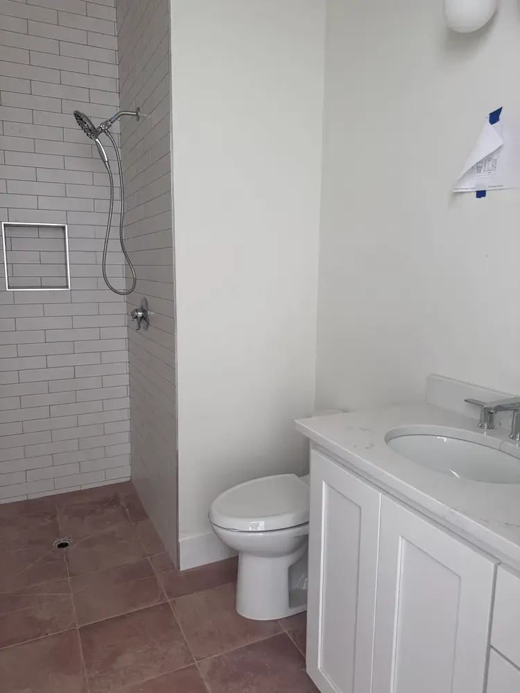 A bathroom with a toilet , sink , and shower.