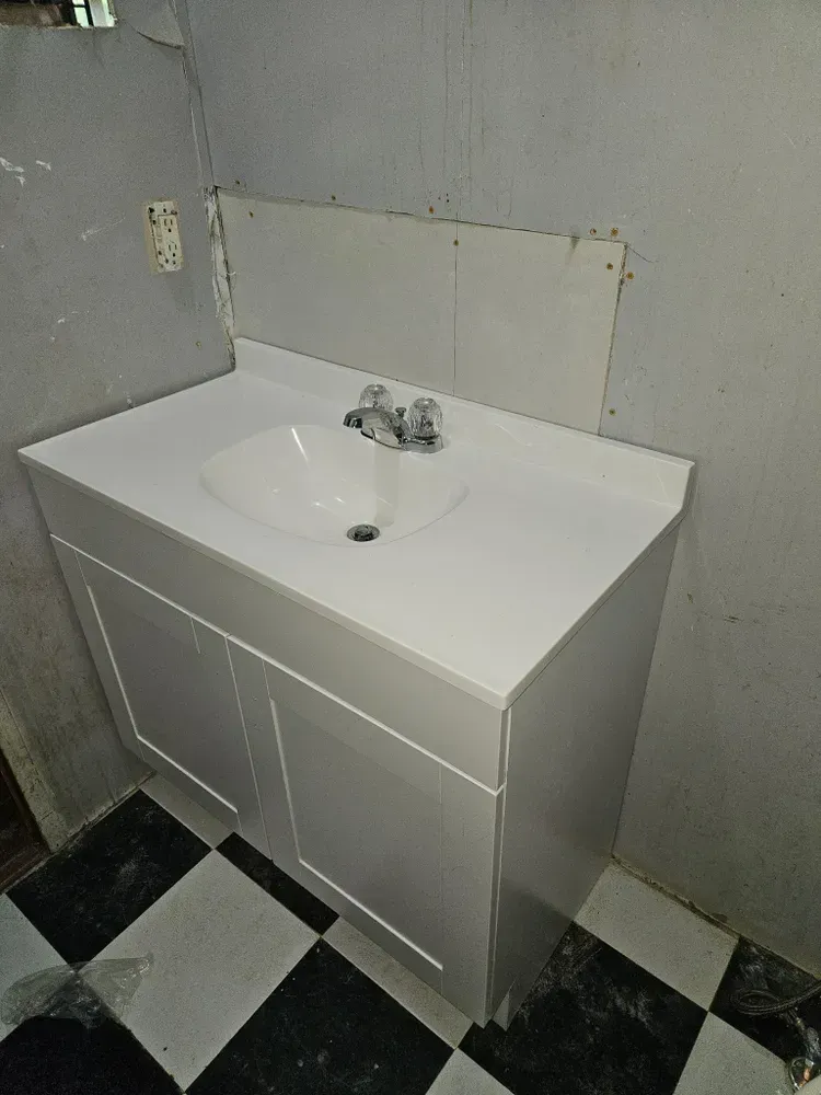 A bathroom sink with a black and white checkered floor.
