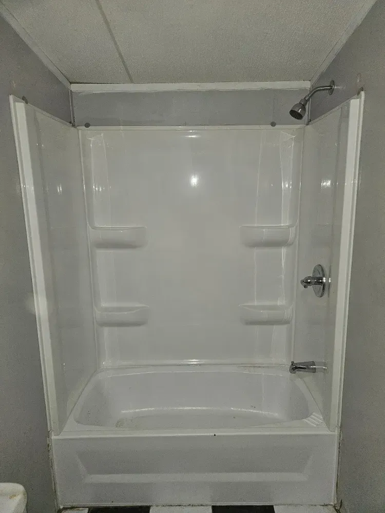 A bathroom with a bathtub and shower stall.