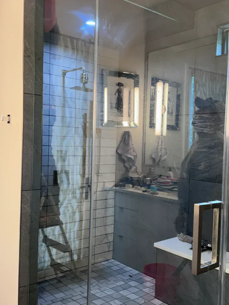 A bathroom with a walk in shower and a sink