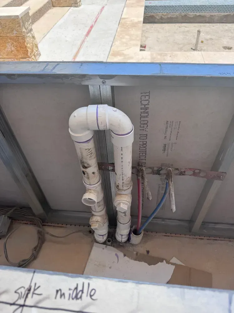 A bunch of pipes are connected to a wall.