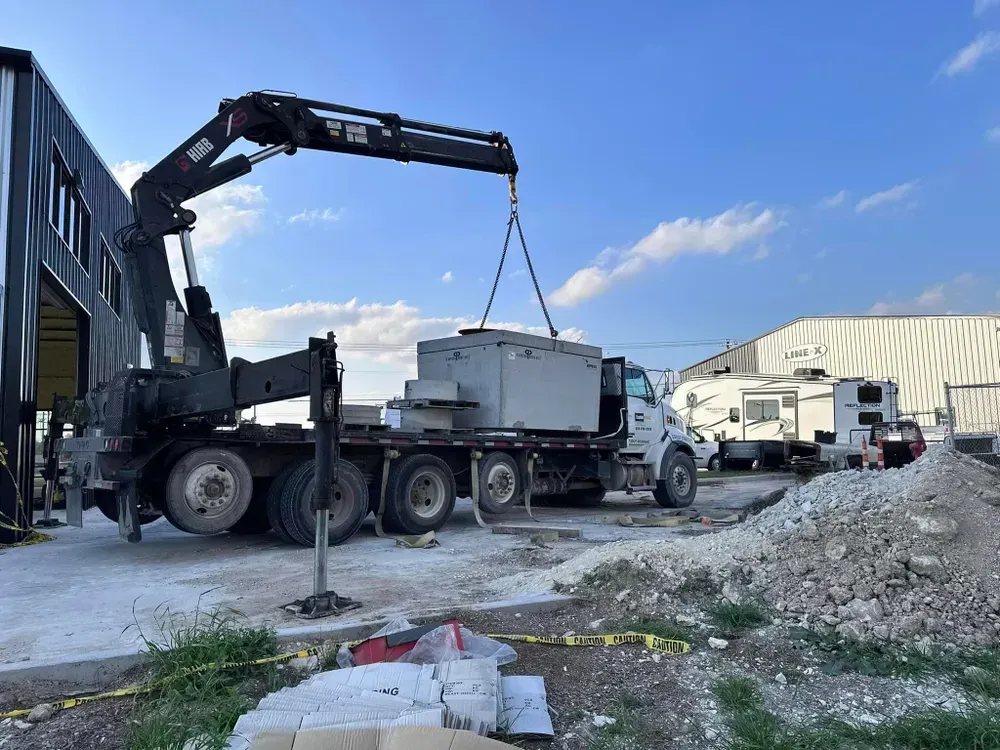 A truck with a crane attached to it is being lifted by a crane.