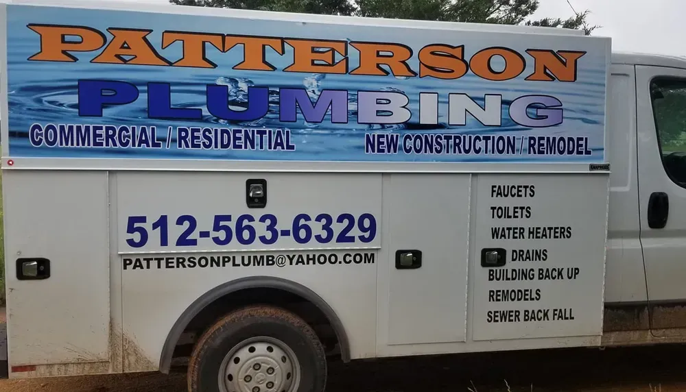 A patterson plumbing truck is parked in the dirt