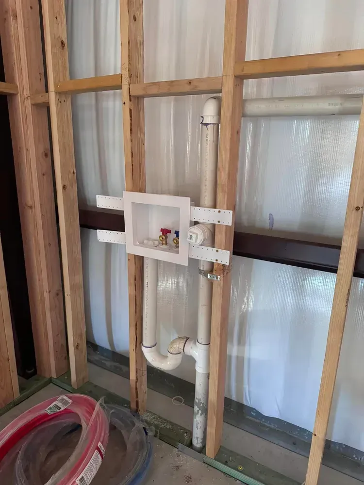 A white pipe is hanging from a wooden wall.