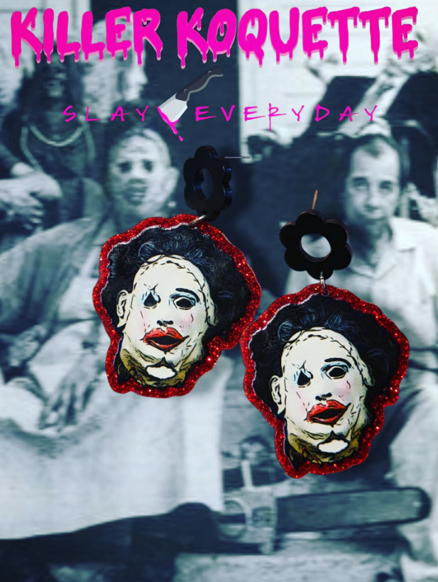 A pair of earrings featuring Leatherface's mask, bordered in red glitter, against a faint black-and-white movie background.
