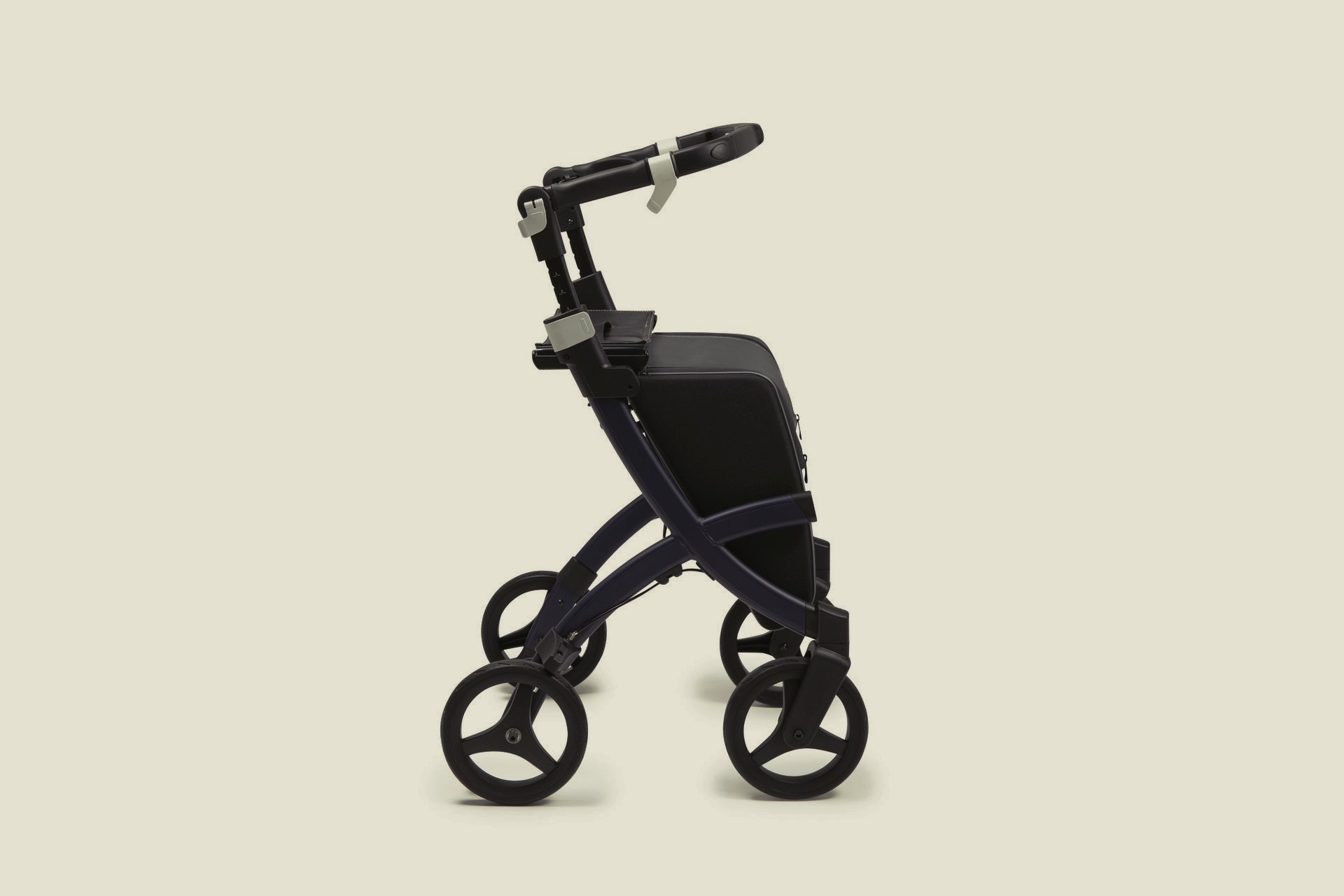 A navy blue, four-wheeled rollator with a black seat and storage bag, viewed from the side against a light background.