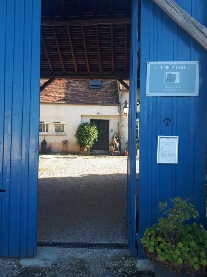 Une porte bleue est ouverte sur une maison avec une pancarte dessus