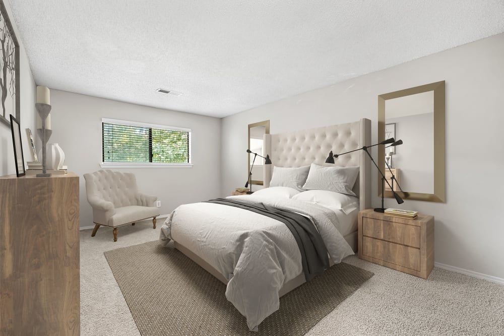 Apartment bedroom with a large bed, dresser, chair, and windows at Marquis at Perimeter Center in Atlanta, GA.