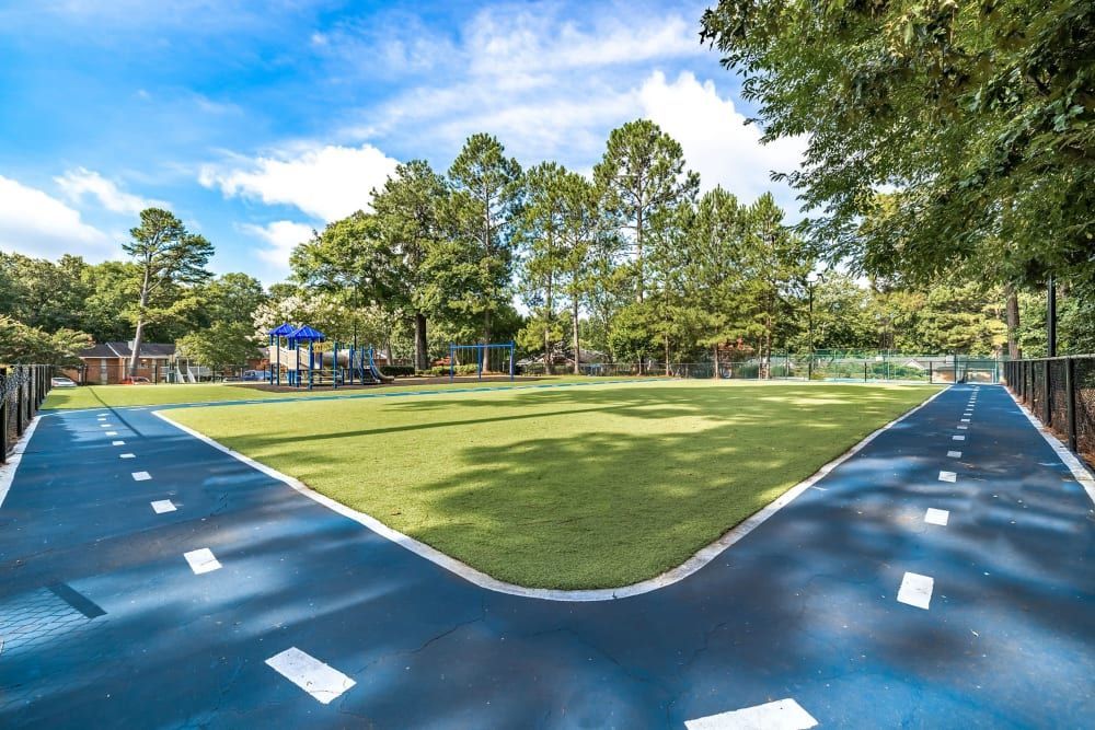 Community walking track with a playground in the background at Marquis at Perimeter Center in Atlanta, GA.