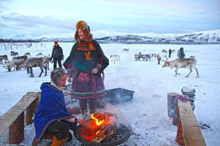 Tromso sami camp sami women burning fire and the ground is covered with snow