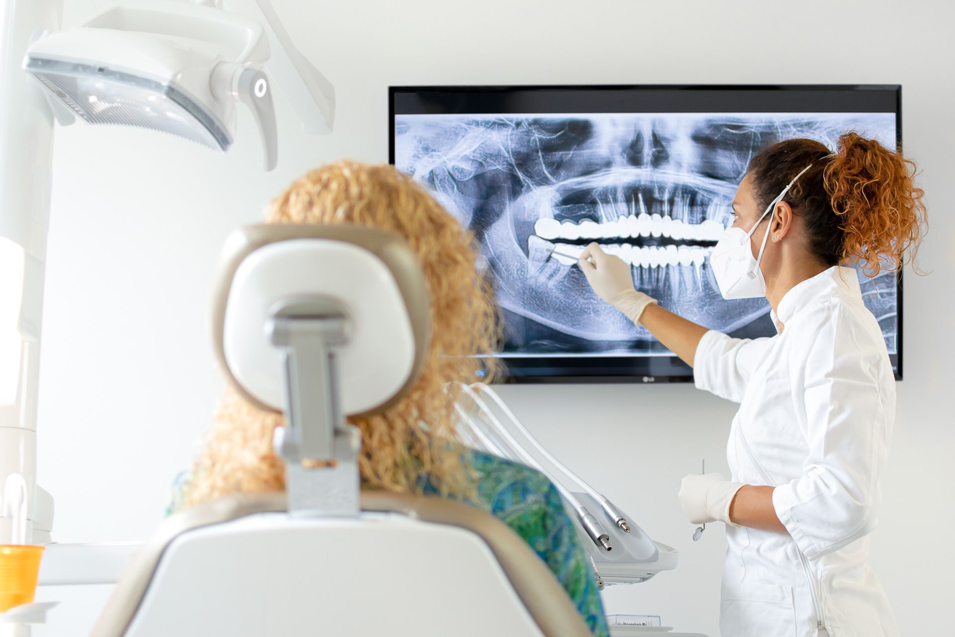 Un dentista sta esaminando una radiografia dei denti di un paziente.