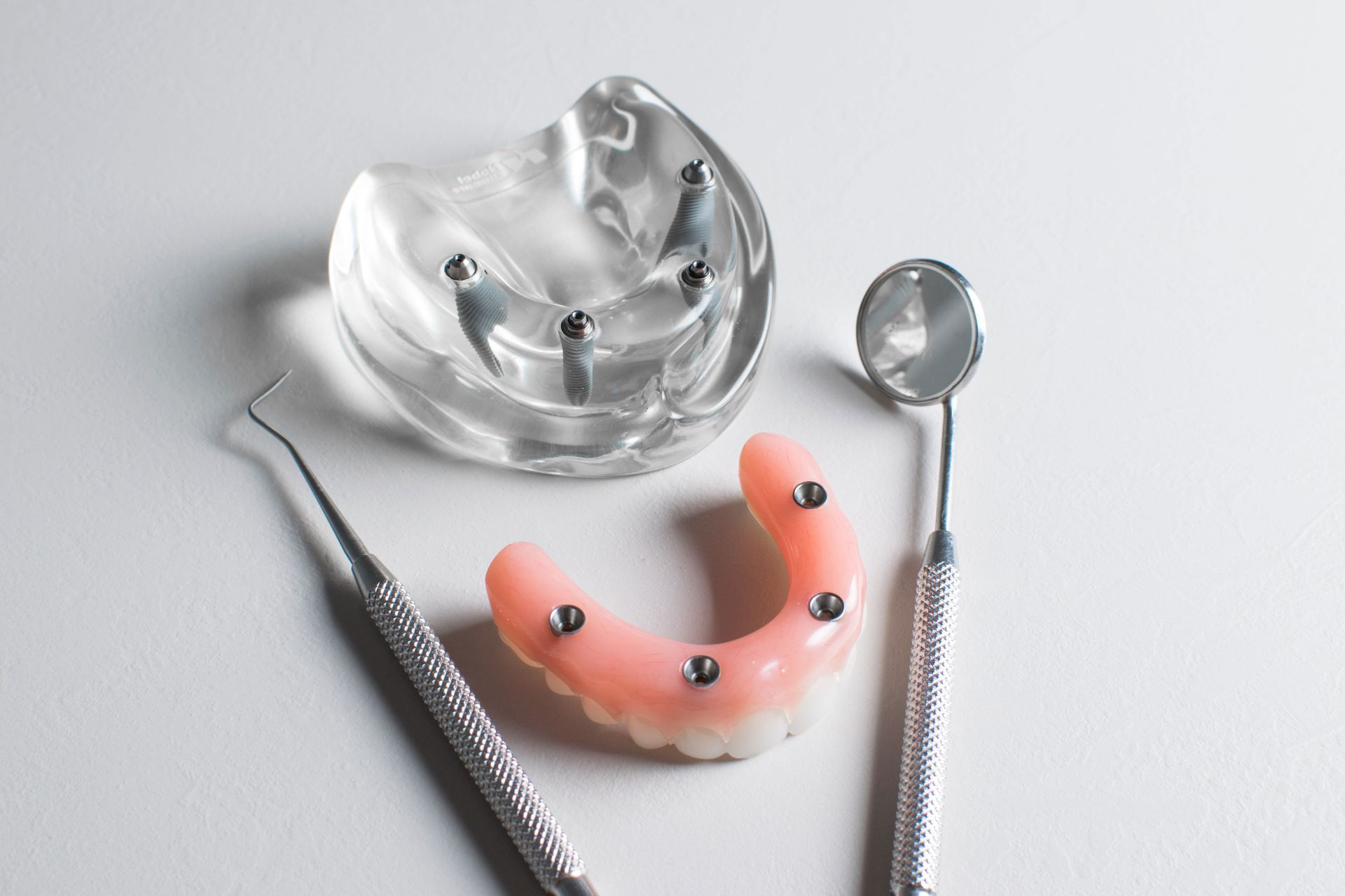 Un modello di protesi dentaria con strumenti odontoiatrici su un tavolo.