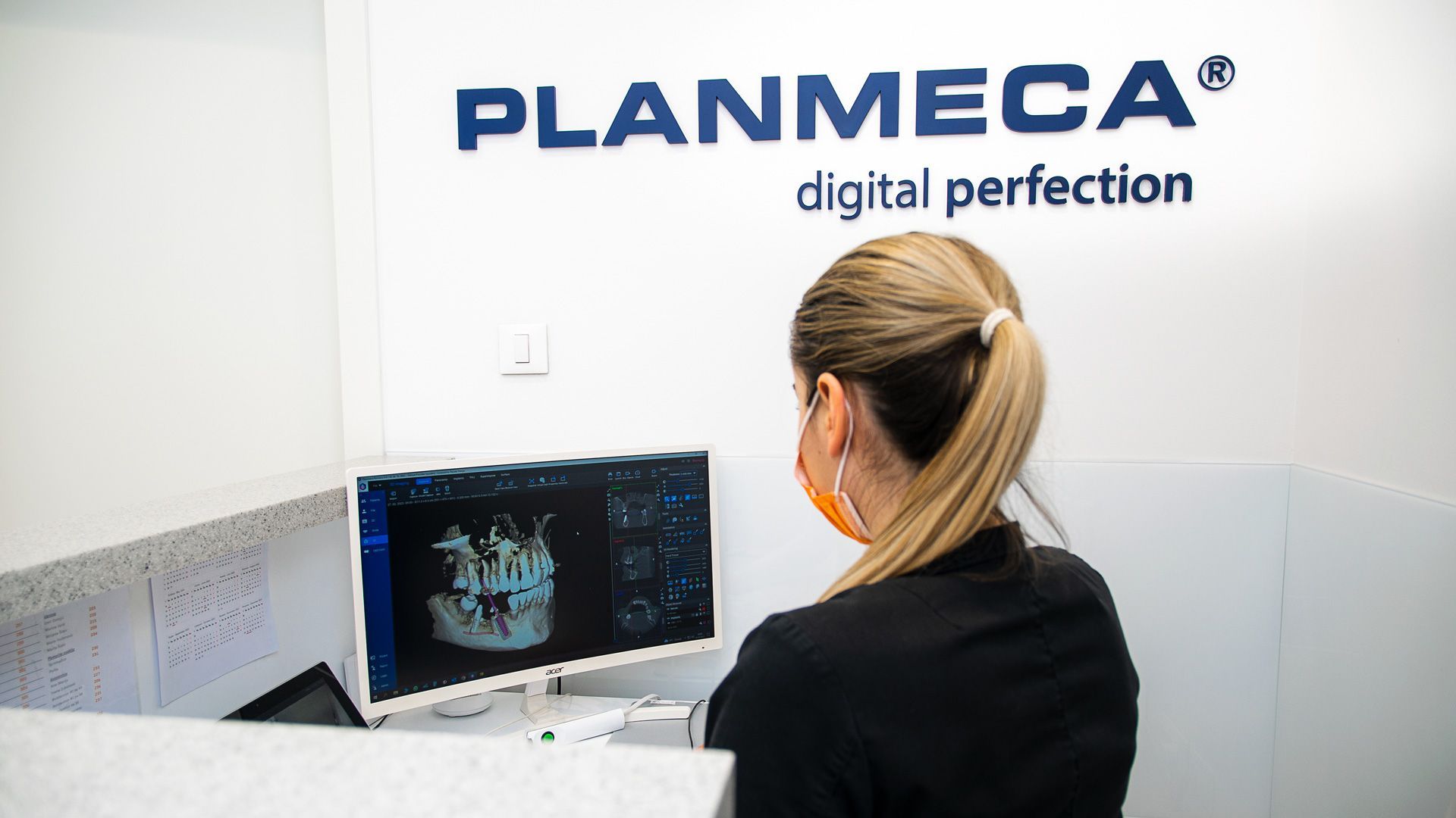 Una donna è seduta davanti a un computer in uno studio dentistico.