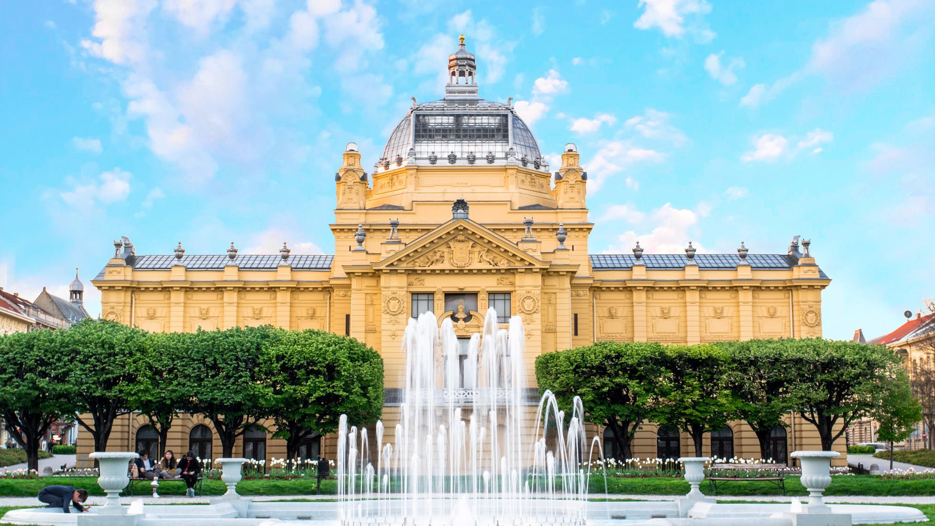 Un grande edificio con una fontana di fronte.