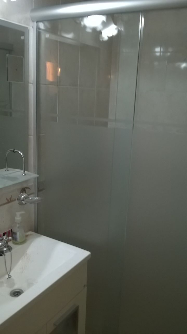 Un baño con lavabo, espejo y cabina de ducha.