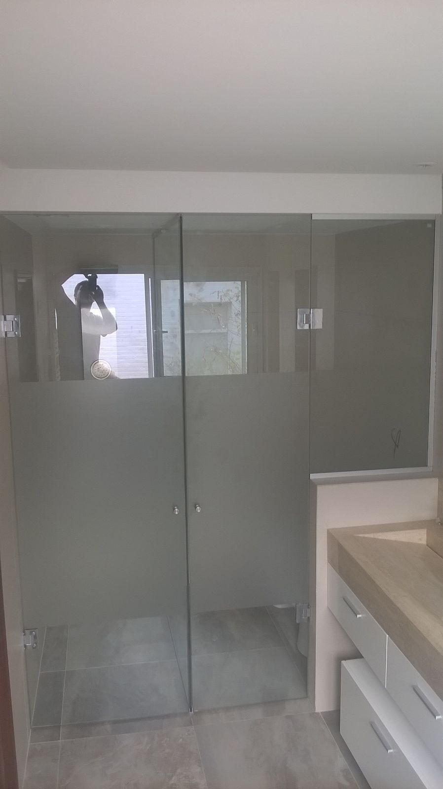 Un baño con mampara de ducha de cristal y lavabo.