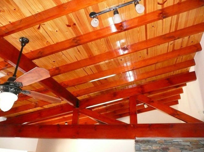 Un techo de madera con ventilador de techo y luces.